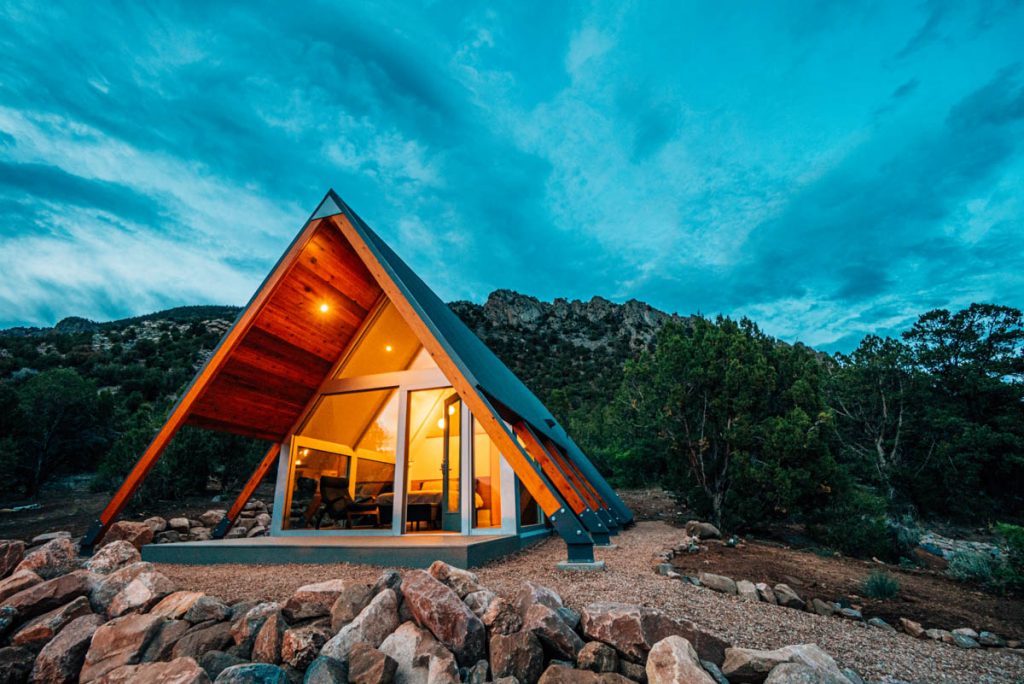 a modern triangle-shaped tiny home at twilight