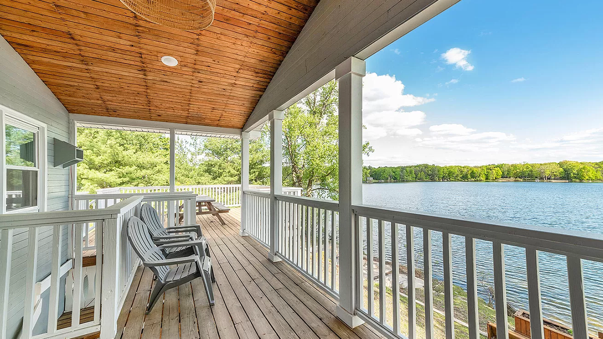 Image of two chairs on a wooden porch overlooking the lake.