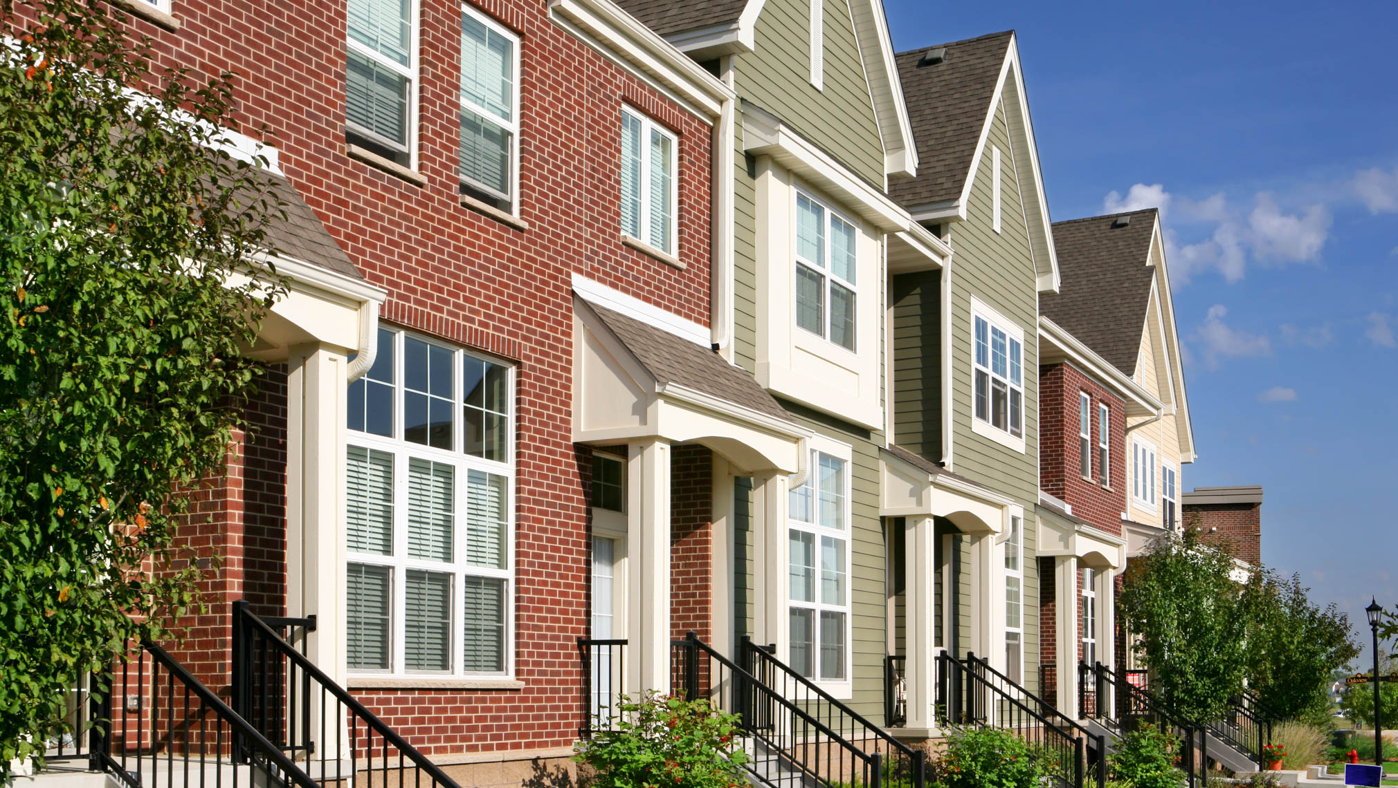 A row of townhomes with brick and beige siding