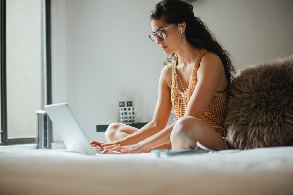 woman on laptop in bed