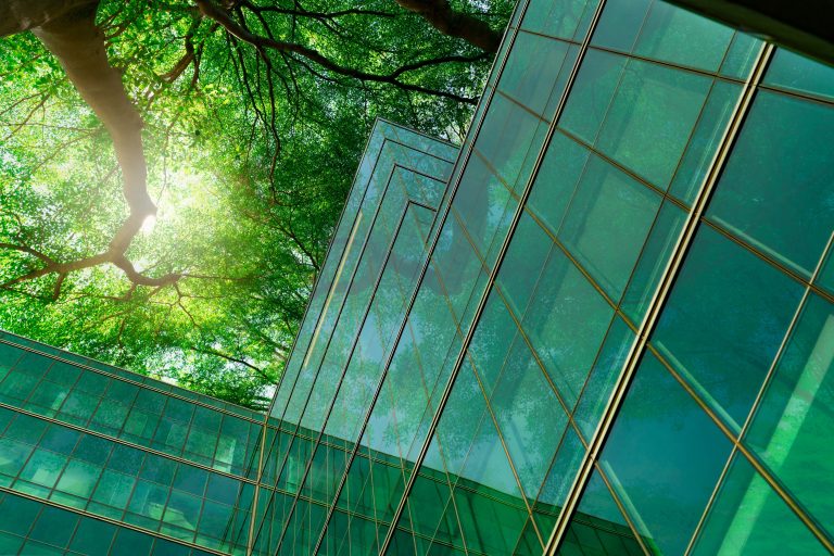 Green trees above a glass building 