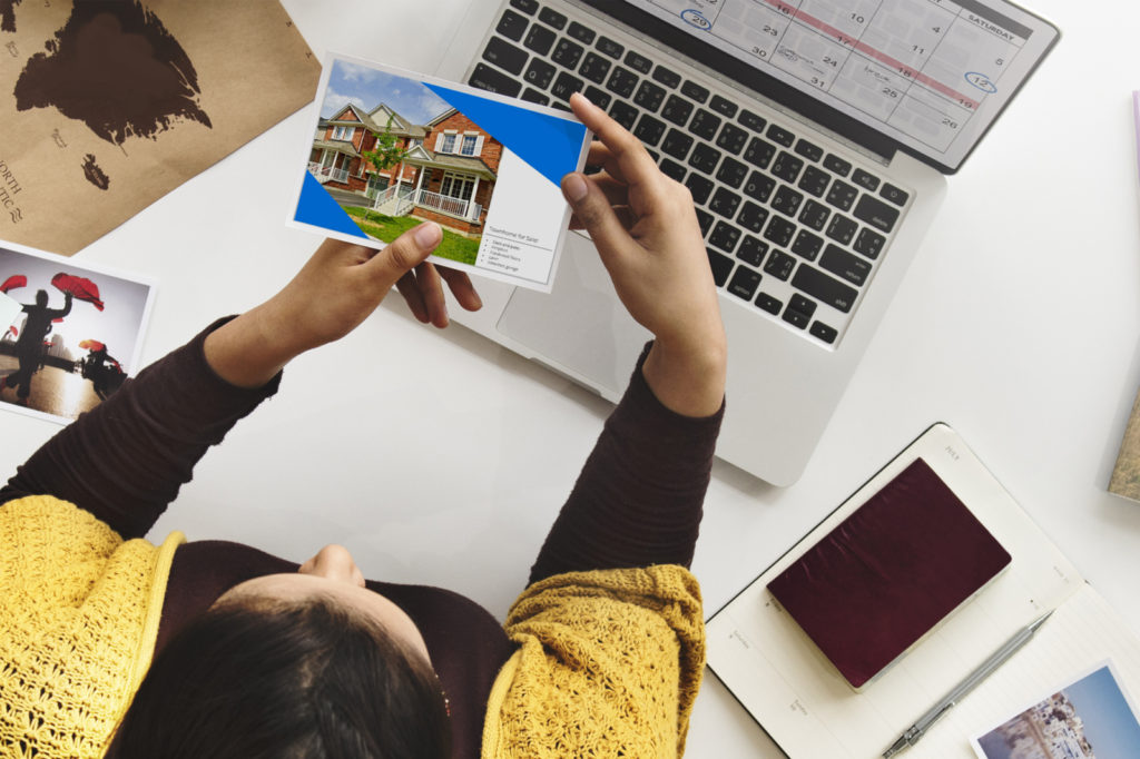 Woman looks at real estate postcards.