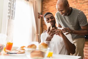 Man showing his partner a home for sale on his smartphone