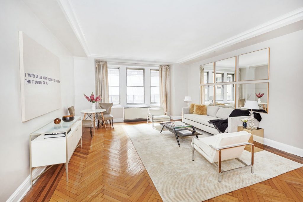 spacious apartment living room with white walls and natural light what is a pied-à-terre