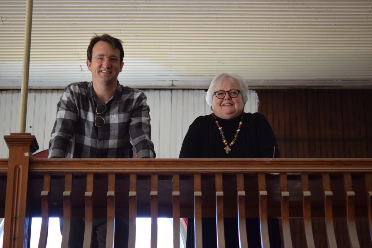 Man and woman stand on interior balcony of historic building