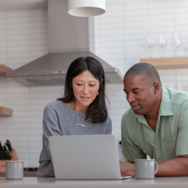 man and woman looking at laptop computer screen