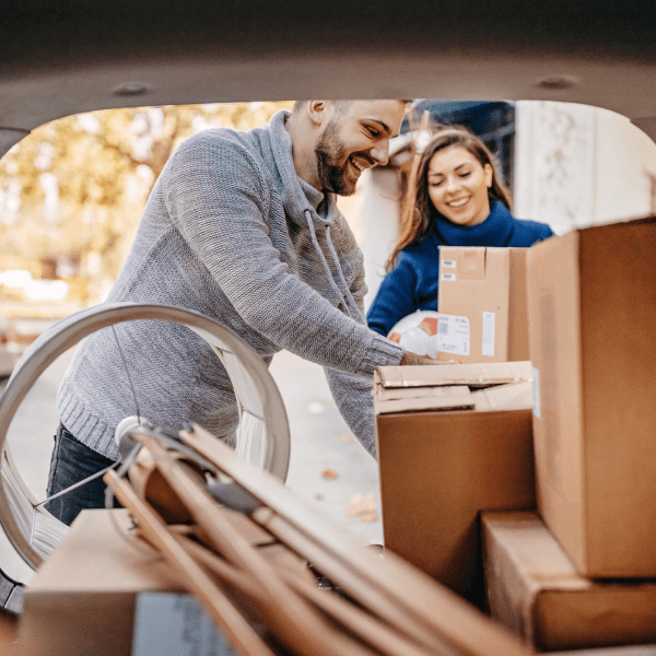 man and woman loading boxes into a car