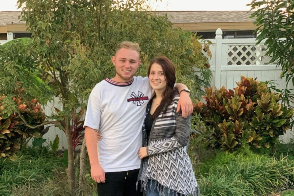 A man and woman standing in front of a house